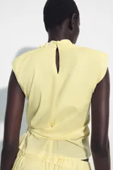 Falda midi de tiro medio, confeccionada en mezcla de lyocell, con cintura elástica fruncida y diseño amplio de corte fluido.