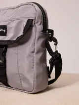 Bandolera negra de nylon con correa ajustable y logo Rusty estampado en blanco.