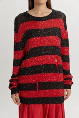 Buzo tejido de punto con diseño de rayas horizontales en negro y rojo, con acabado brillante de lentejuelas y detalles desgastados.