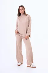 Buzo tejido de punto color negro, con cuello alto, manga larga y corte holgado con aberturas laterales en el ruedo.