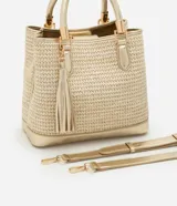 Cartera satchel mediana color dorado, con textura de paja, correa de mano, asa larga desmontable y detalle de tassel.