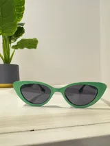Lentes de sol verdes con forma de ojo de gato y cristales negros.