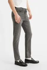 Jean skinny de hombre color gris oscuro, de tiro medio, con lavado desgastado y sin elasticidad.