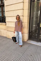 Canguro con capucha de manga larga, color marrón topo, de calce amplio y tejido suave. Presenta bolsillo canguro frontal y puños y ruedo ajustados.