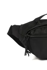 Riñonera negra con dos compartimentos con cierre, correa ajustable y parche frontal con la leyenda 'Not just a bag'.