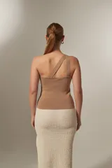 Top sin mangas de tejido liso, corte al cuerpo, con escote asimétrico de un solo hombro.