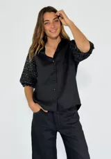 Camisa beige de lino con mangas 3/4 con lentejuelas negras.