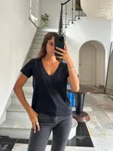 Camiseta básica de algodón orgánico color negro, con cuello en V y manga corta. Presenta un pequeño logo bordado al tono en el pecho.