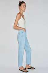 Pantalón jeans Z1975 de tiro alto y diseño mom fit, color azul claro con lavado desgastado, de corte tobillero y cinco bolsillos. Cierre frontal con cremallera y botón metálico.
