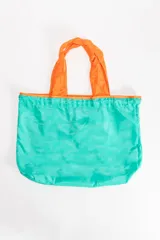 Bolsa de compras plegable de tela ligera en color verde con manijas en color naranja.