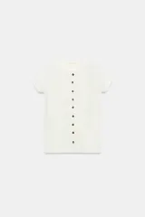 Camiseta de canalé color blanco, de corte slim fit, cuello redondo, manga corta y cierre frontal con hilera de botones oscuros a contraste.