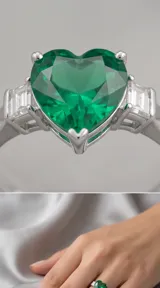 Anillo de plata 925 con piedra central en forma de corazón de color verde y detalles de circonias tipo baguette en los laterales.