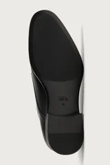 Zapato de vestir tipo monk de color negro, con detalle de doble hebilla metálica plateada en el empeine, puntera redondeada y suela con ligero tacón.