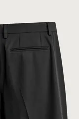Pantalón de traje slim fit color negro, confeccionado en tejido con viscosa, con bolsillos frontales, bolsillos traseros de doble vivo y raya marcada en las piernas. Cuenta con cierre frontal con cremallera y botón.