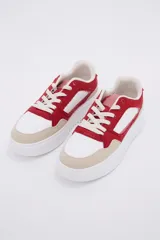 Zapatillas deportivas blancas con detalles en rojo y beige.