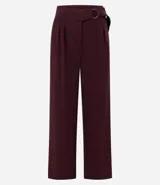 Pantalón de corte wide leg confeccionado en crepé color bordó, con cintura alta, cierre frontal con cremallera y detalle de hebilla ajustable en la cintura.