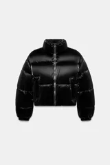 Anorak acolchado de efecto brillante con tejido cortavientos y repelente al agua. Presenta cuello subido, cierre frontal con cremallera, bolsillos delanteros con forro polar y cierre de cremallera, y mangas largas con puños elásticos. El bajo es ajustable con cordones elásticos laterales.