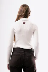 Polera de punto acanalado en color marrón chocolate, con cuello alto y mangas largas ajustadas.