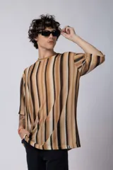 Remera de tejido tipo crochet con diseño de rayas verticales en tonos tierra, beige y negro. Presenta un corte oversize con mangas cortas y cuello redondo.
