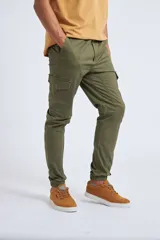Pantalón cargo color beige con ajuste slim, cierre frontal con botón, bolsillos laterales tipo cargo y puños elásticos en los tobillos.