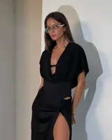 Body negro con escote drapeado, mangas cortas y falda larga con tajo alto y abertura en la cintura.