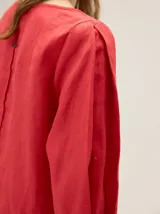 Blusa de algodón color beige, de diseño amplio con mangas tres cuartos abullonadas y cuello redondo.