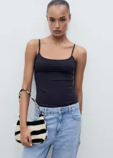Top negro de breteles finos, escote recto y corte ajustado al cuerpo.