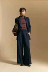 Pantalón de vestir negro de corte ancho y tiro alto, con silueta fluida y diseño minimalista.