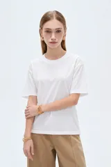 Remera blanca de manga corta, cuello redondo a la base y diseño holgado, confeccionada en algodón.