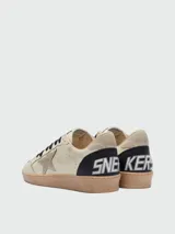 Zapatillas Golden Goose modelo Ballstar confeccionadas en cuero nappa color crema, con estrella laminada en el lateral, cordones negros y suela de goma con efecto desgastado.