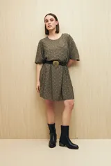 Vestido corto con estampado animal print en tonos beige, negro y marrón. Tiene corte holgado, mangas cortas y falda con vuelo.