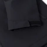 Chaqueta técnica negra de Caterpillar, diseñada con tecnología Storm Blocker+ para protección contra agua y viento. Cuenta con capucha ajustable y extraíble, cierre frontal completo con protector de barbilla, bolsillo en el pecho y bolsillos laterales con cremalleras impermeables, y logo de la marca en el brazo.