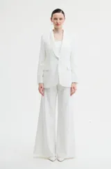 Pantalón de vestir blanco de silueta amplia y tiro alto, con caída fluida y diseño sastrero.