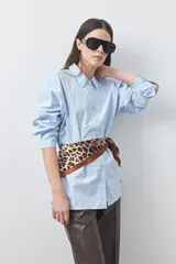 Camisa de manga larga de algodón en color blanco, con cuello clásico, cierre frontal de botones y silueta relajada.