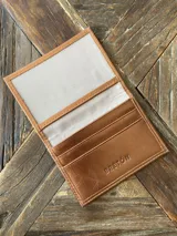 Tarjetero de cuero vacuno color dorado, con ranuras para tarjetas y bolsillo exterior en la parte trasera. Marca Bretoni.