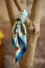 Pañuelo cuadrado de seda con estampado botánico y naturalista en tonos celestes, blancos y detalles en rosa, inspirado en la obra de Dámaso Antonio Larrañaga.