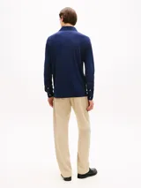 Chomba de manga larga Tommy Hilfiger en color azul marino, confeccionada en mezcla de algodón y modal con punto interlock. Presenta cuello clásico de chomba, cartera de cuatro botones y el logo de la marca bordado en el pecho.