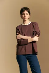 Remera de manga larga con calce relajado y cuello redondo, confeccionada en algodón de color blanco.