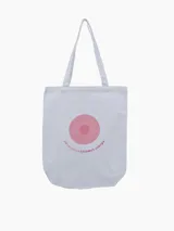 Bolso tipo tote de tela color blanco con asas largas. Estampado circular en color rosa con texto "EN LA LUCHA ESTAMOS JUNTOS".
