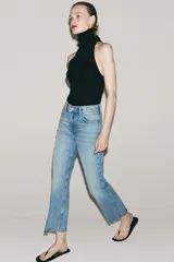 Jeans cropped flare de tiro medio color celeste, confeccionados en denim con efecto lavado. Presentan diseño de cinco bolsillos, trabillas para cinto, raya planchada al frente y bajo desflecado con terminación evasé. Cuenta con cierre frontal de cremallera y botón metálico.