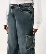 Pantalón de jean wide leg color azul, de tiro medio con bolsillos cargo laterales y diseño amplio en las piernas.