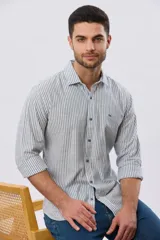 Camisa de lino rayada de manga larga, con cuello camisero, cierre frontal de botones y bordado sutil en el pecho.