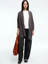 Cardigan de tejido de punto en color marrón, con diseño de silueta relajada, sisa caída, mangas ajustadas y bolsillos frontales.