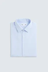 Camisa de corte regular fit en color celeste, con cuello italiano, manga larga con puños abotonados y cierre frontal de botones.