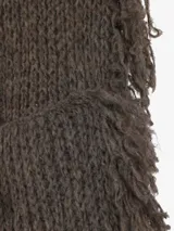 Bufanda tejida de punto grueso, color negro, con flecos largos y desmechados a lo largo de los bordes.