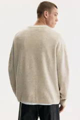 Buzo de punto suave con cuello en V, diseño de corte estándar, mangas largas y terminaciones acanaladas en puños y ruedo.