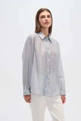 Camisa celeste de lyocell con textura arrugada, corte holgado, cuello clásico y cierre frontal con botones.