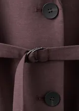 Blazer de lino y viscosa color marrón, de diseño recto, cuello en pico con solapa, mangas tres cuartos, dos bolsillos con solapa, cierre frontal con botones y cinturón integrado a juego.