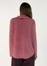 Remera de manga larga con cuello polo y cierre frontal de dos botones. Presenta un diseño de corte recto y acabado desgastado en las costuras.