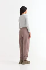 Pantalón jogger de felpa color marrón, con cintura elástica ajustable mediante cordón, bolsillos laterales y puños elásticos en los tobillos.